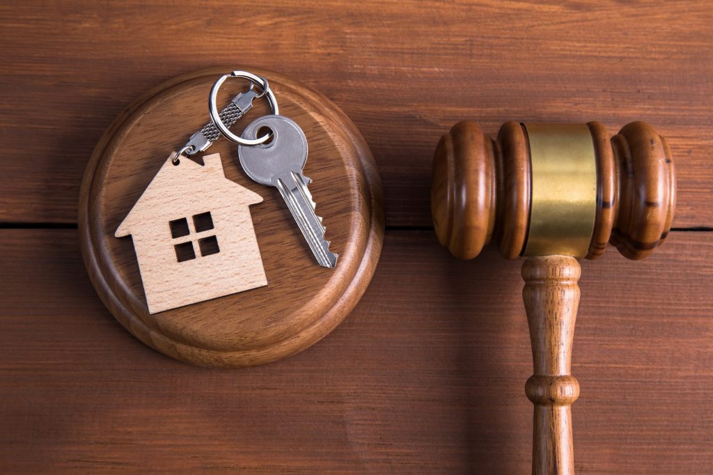 Image d'un marteau de juge et d'une clé de domicile qui ont un lien avec la liquidation de bien